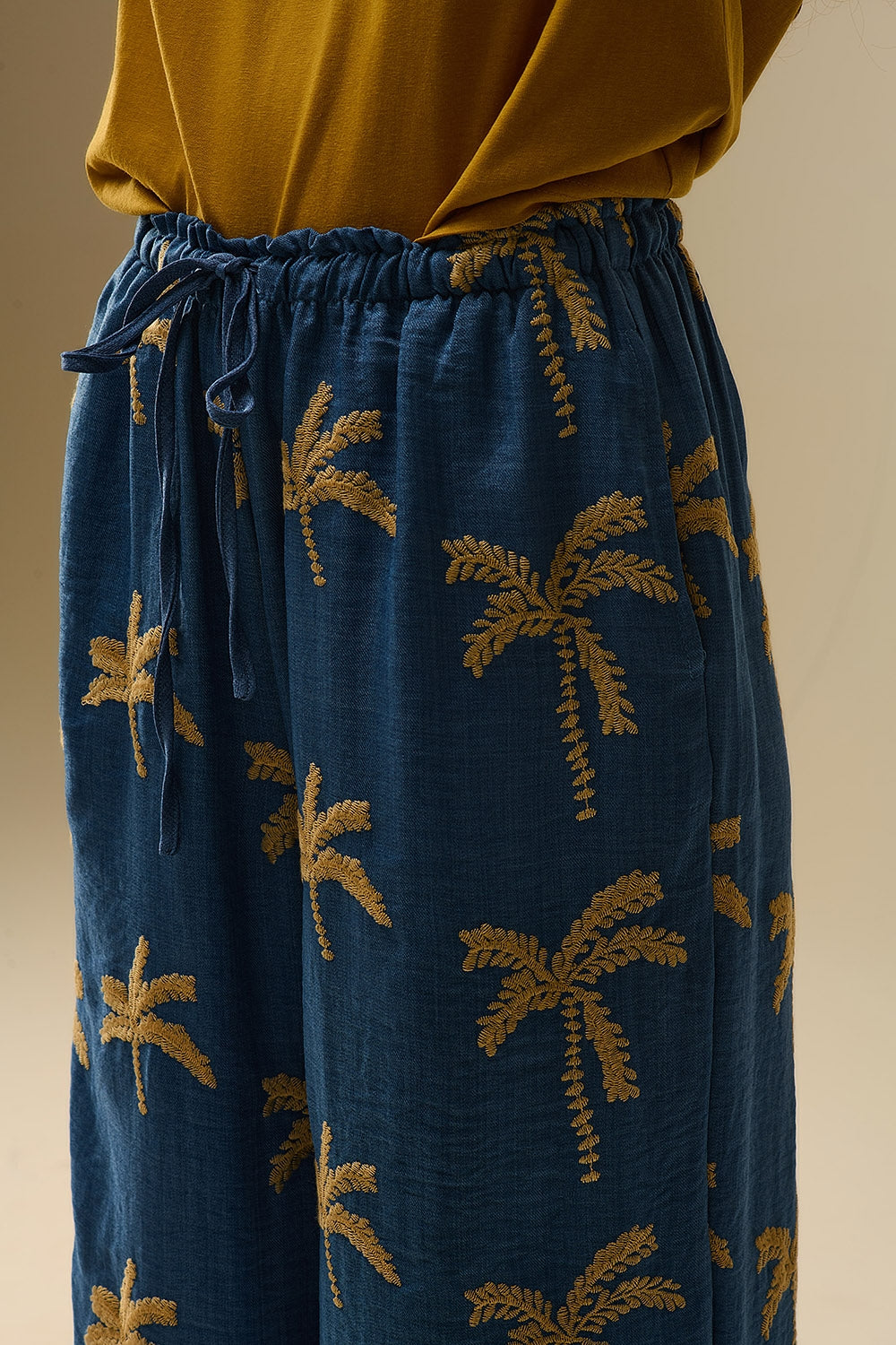 Blauwe Broek Met Wijde Pijpen En Beige Palmboom Borduursel